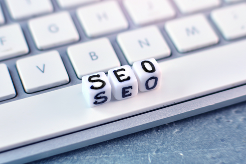 "SEO" word blocks sitting on a white keyboard.